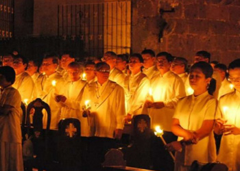 A group of parishioners holding candles to renew their baptismal promises